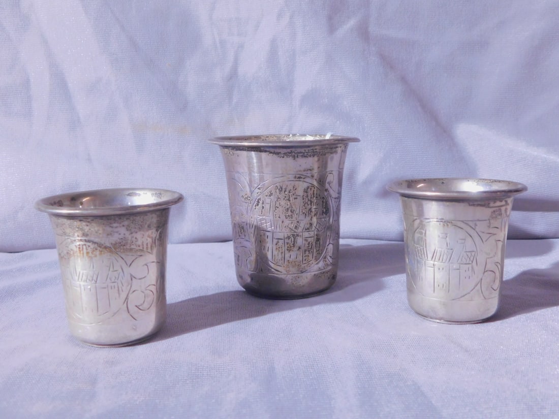 3 Russian Kiddush Cups: Three Russian Kiddush Cups, all with 84 silver and other touch marks plus engraved owners initials; bodies with village scene cartouches and scroll work, late 19th C, two 1 7/8"h, one 2 1/2"h, 4.55 oz