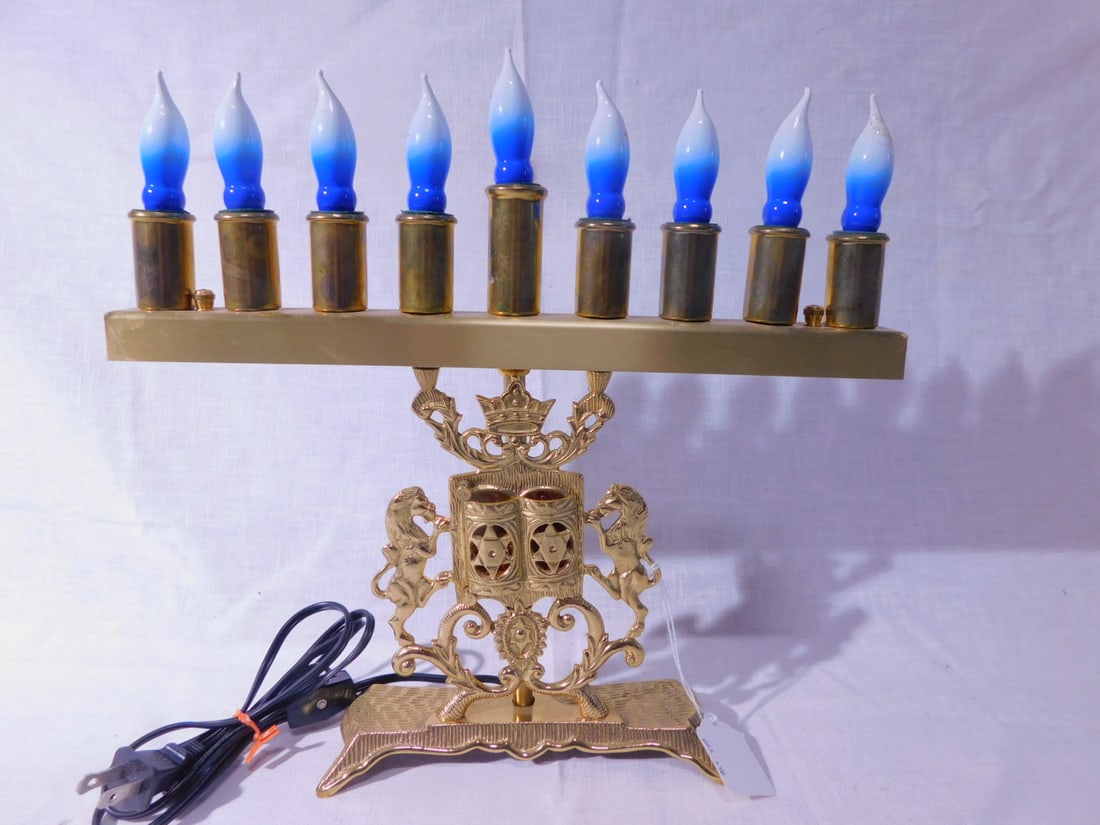 Brass Menorah: Brass Menorah, electric, features, pair of lions of Judah flanking a swing door ark with enclosed Ten Commandments and crown, 12 1/2"h, 13"l. [246] CONDITION: Very good, working.