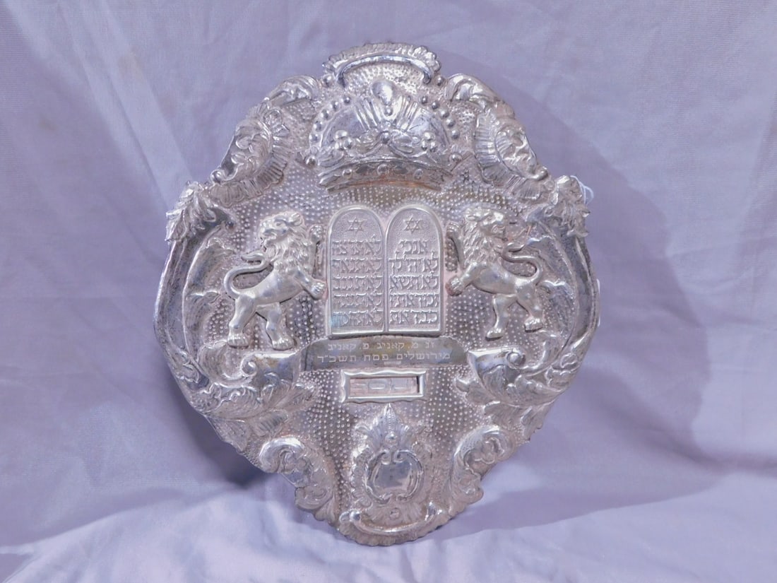 Torah Breastplate: Torah Breastplate, marked sterling silver, embossed acanthus scrolls, tablets of the Laws, crown and cartouche, hand chaised, applied Lions of Judah, Hebrew dedication, 12" x 10 1/2", 16.15 ozts.[17]