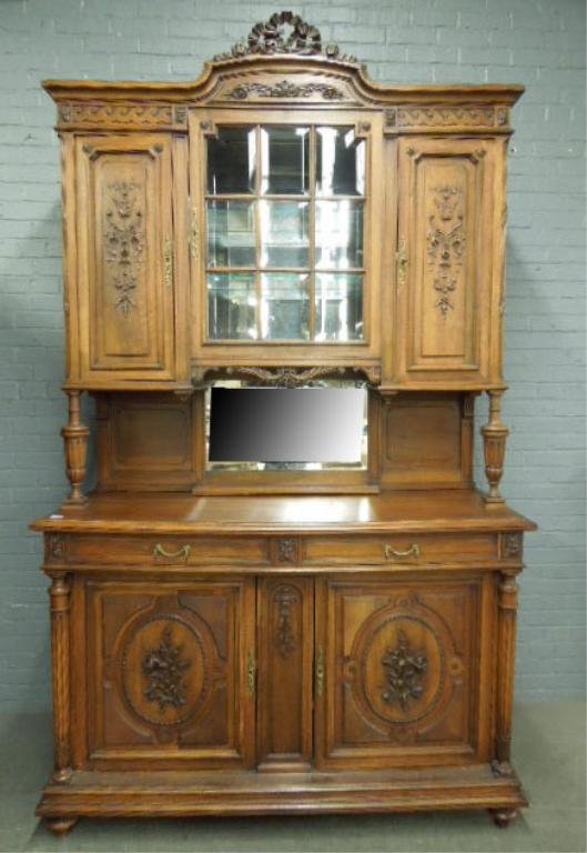 Late 19th c. French Breakfront: Late 19th century French breakfront with beveled glass door, floral carved raised panel doors top and bottom, ribbon carved crest, column post sides (bottom and on hutch top), brass escutcheons and dr