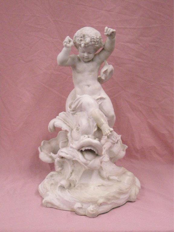 19th c. English Parian Sculpture: 19th c. unsigned English Parian porcelain 21" x 13" x 17" sculpture, depicting a cherub riding a dolphin on a wave. CONDITION: Old repairs on foot, back of cherub and wave base, broken staff in cherub