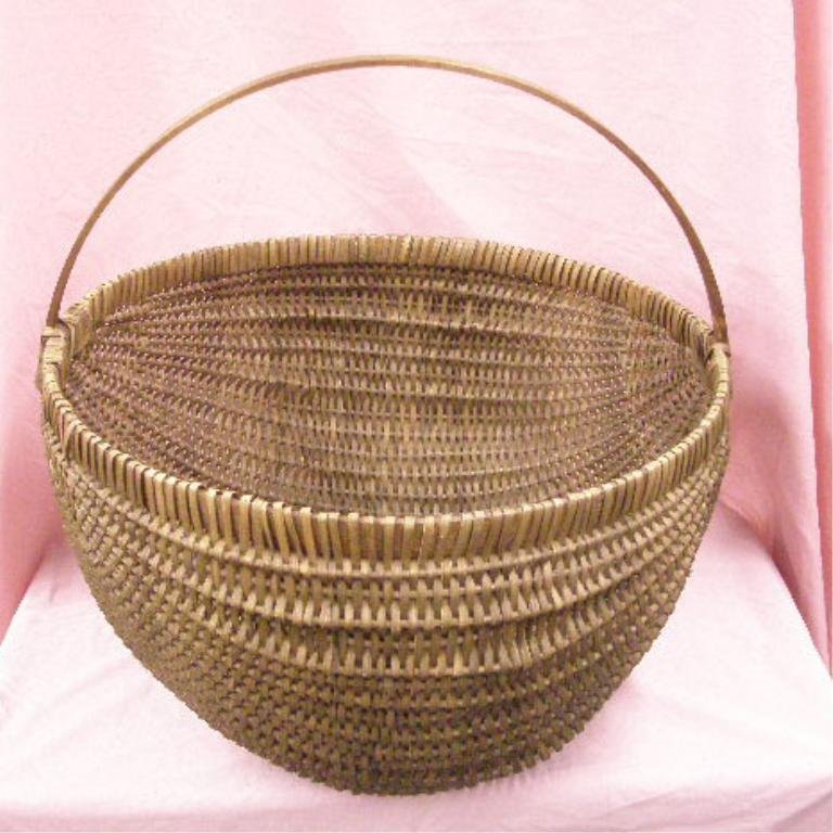 Antique Wicker Basket: Antique wicker 21 1/2" x 22" x 23" basket with splint wood handle. CONDITION: Very good with areas having wear.