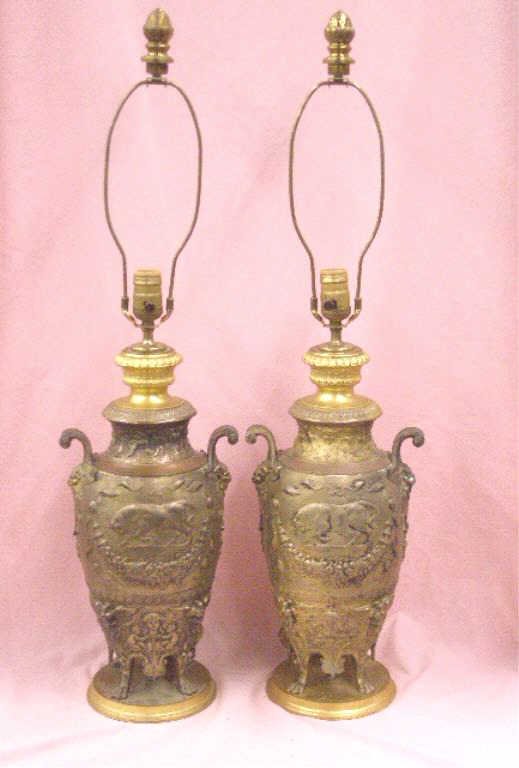 Ferdinand Levillain French Bronze Lamps: Pair of 19th c. Ferdinand Levillain signed French bronze urn form lamps, 13" urns with relief bulls, cherubs and floral designs with four paw feet, electrified and mounted as lamps, Dore bronze cap to