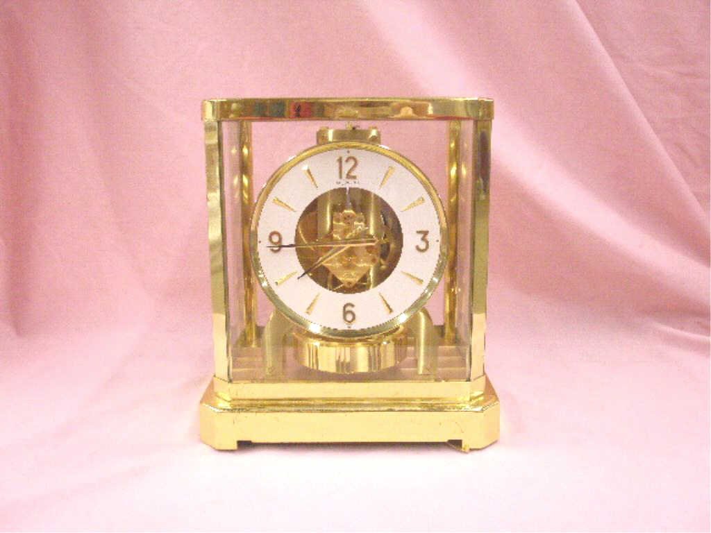 Jaeger LeCoultre Atmos Clock: Vintage Jaeger LeCoultre brass and glass cased 9 1/2" x 8 1/4" x 6" perpetual Atmos mantle clock. CONDITION: Not known if it works, presentation plaque applied on front bottom panel, minor wear.