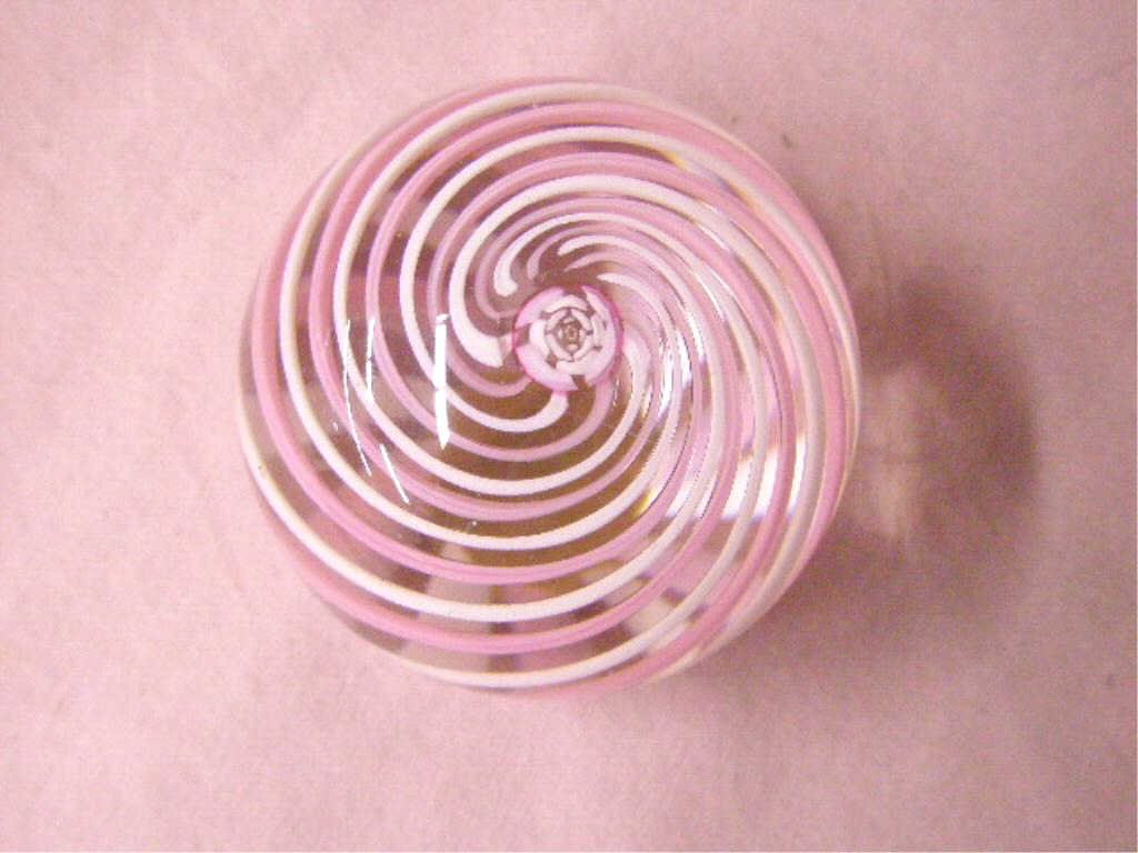 Contemporary Pairpoint Glass Paperweight: Contemporary Pairpoint Glass Company signed clear glass 1 1/2" x 1 3/4" paperweight with pink and white swirl design. CONDITION: Very good with minor wear and no damage.