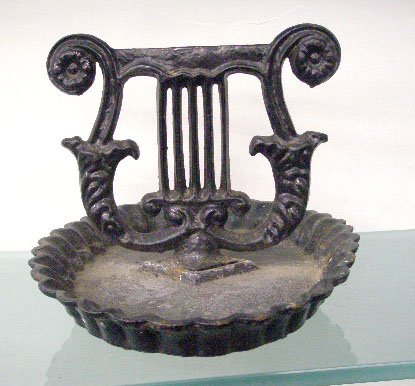 Antique Cast Iron Boot Scraper: Antique painted cast iron 8" x 11" boot scraper, lyre form center on scalloped edge base. Condition: Areas with wear & loss from usage.