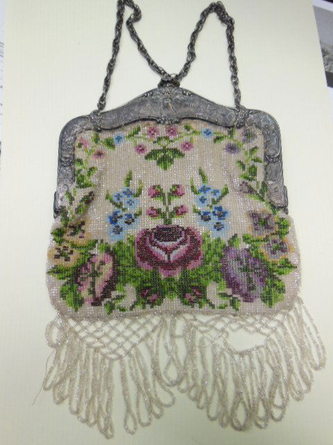 Antique Glass Beaded Handbag: Antique glass beaded 10" x 7" evening bag with floral designs on both sides, silver plate frame with relief Dutch scenic & landscape designs on both sides, brown kid leather lining. Condition: Needs t