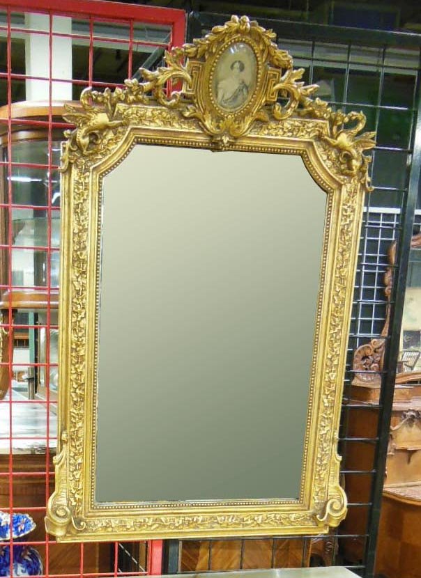 French Baroque Style Wall Mirror: French Baroque style wall mirror, gilt & carved wood frame with hand colored portrait engraving on garland & Griffin carved crest, 19th c. 32" x 45 1/2". CONDITION: No issues noted.