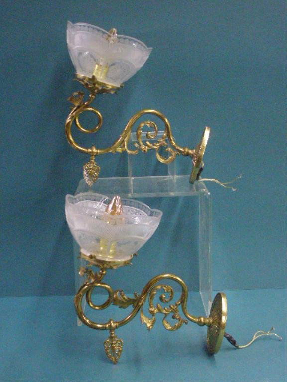 Brass Rococo Style Wall Sconces: Pair of contemporary brass Rococo style 12 1/2" x 13 1/2" electrified wall sconces with glass shades. CONDITION: Both are very good with minor wear.