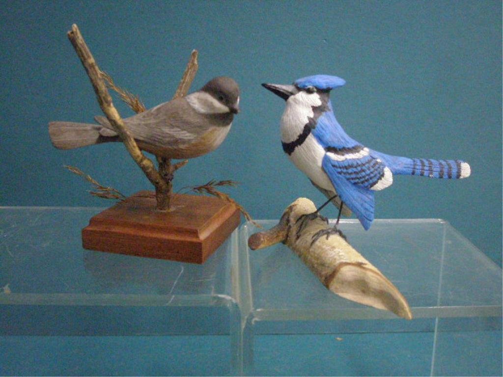 Signed Wood Bird Carvings: Bill Johnson & Gary Wilde signed 5" x 7" x 6" Blue Jay & 5" x 3" x 3" Black caped Chickadee, wood bird carvings. CONDITION: Both are very good with minor wear, small loss on beak of chickadee.