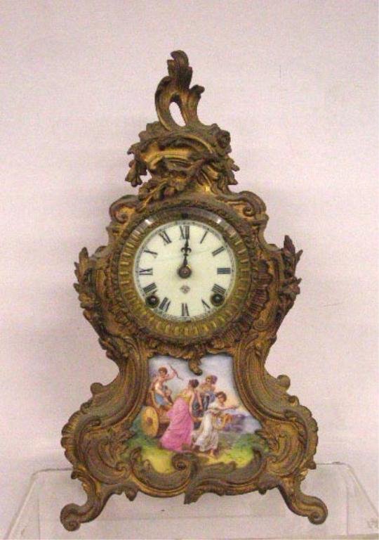 19th c. Ansonia Mantle Clock: 19th c. Ansonia Clock Co. gilt metal 14 1/2" x 8" x 4 1/2" mantle clock with a hand painted porcelain panel set into bottom portion of case, & porcelain face with time & strike movement. CONDITION: Mi