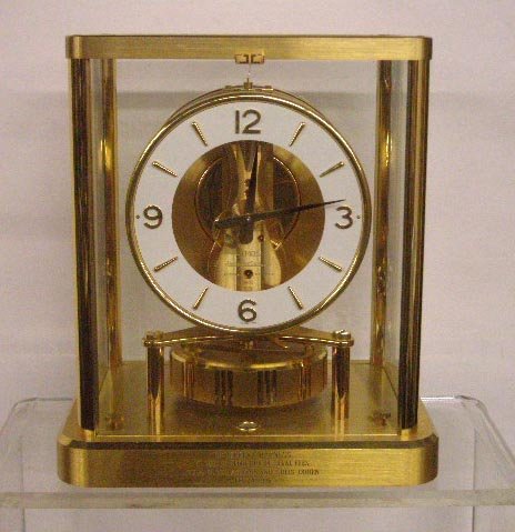 Jaeger LeCoultre Atmos Clock: Jaeger LeCoultre brass & glass cased 9 1/2" x 8 1/4" x 6" perpetual Atmos mantle clock. CONDITION: Clockworks are intact but it is unknown if the clock works, presentation inscription on front bottom 