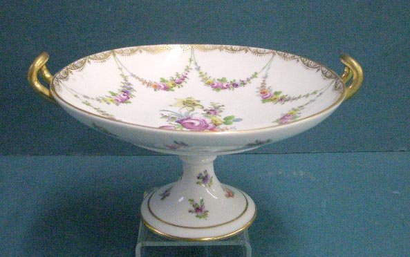 Dresden Porcelain Footed Compote: Circa 1930 Franziska Hirsch Dresden porcelain 4" x 8 1/4" x 7 1/2" footed compote with applied gilt painted handles & hand painted floral designs. CONDITION: Very good with no damage.