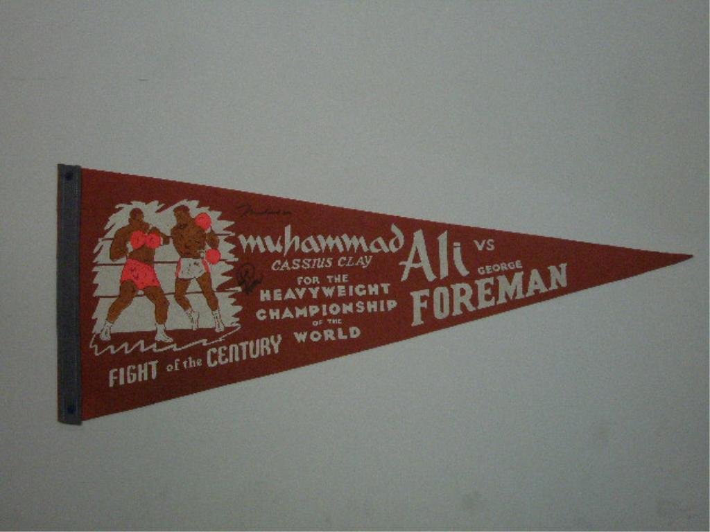 Muhammad Ali & George Forman Signed Pennant: Muhammad Ali & George Forman signed 1974 Heavyweight Championship Boxing pennant, no C.O.A. for authenticity or guarantee of signatures being real. CONDITION: Signatures are faded, tack holes.