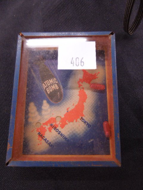 Vintage Atom Bomb Puzzle Game: Vintage Atom Bomb Puzzle Game. Features capsule form bombs and illustrated map of Nagasaki, Hiroshima & Tokyo circa late 1940's made of metal cardboard and glass. Condition: Slight paint loss.
