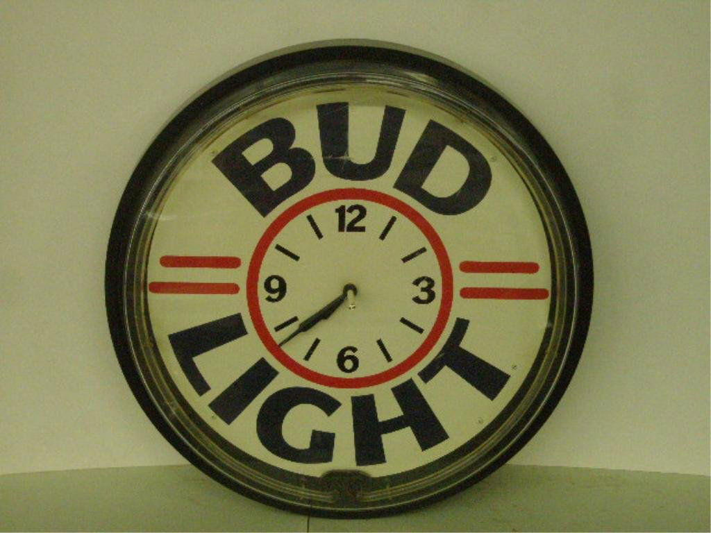 Bud Light Clock: Bud light electric wall clock with neon circumference light, 18" diameter. CONDITION: Scratches in plastic front, not guaranteed working.