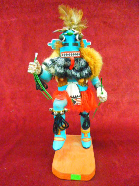 Hopi Kachina Doll "Corn Dancer": Contemporary S.W. Hopi Kachina doll; "Corn Dancer", with whips & stalks, artist signed "H (enry) Shelton", Oraibi, Ariz. Hand carved, polychrome hand painted with feathers, fur?, shell strap vest, bel