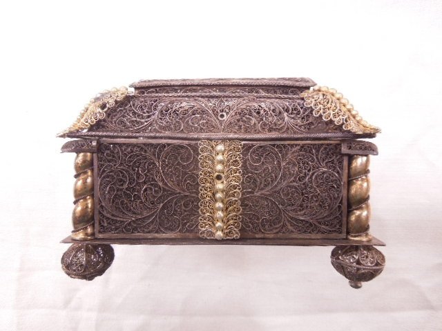 800 Silver Jewelry Casket: 800 silver jewelry casket, tested, filigree scroll work, ball feet and applied gilt accents, early 20th C., 6" x 4 1/4" x 4 1/4", 16.2 ozts. CONDITION; Feet are loose, slight crushing on arched portio