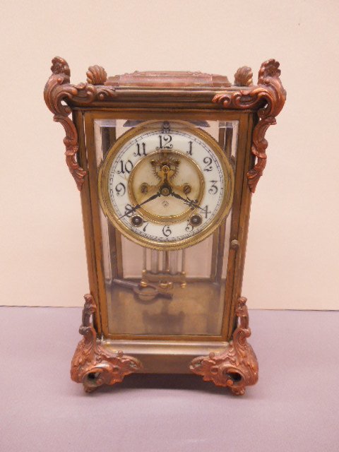 Ansonia Crystal Regulator Clock: Ansonia crystal regulator clock, porcelain dial with open escapement, brass and beveled glass with applied copper plated acanthus and scroll mounts and feet, early 20th C., 7b 1/2" x 6 1/2" x 12 1/4".