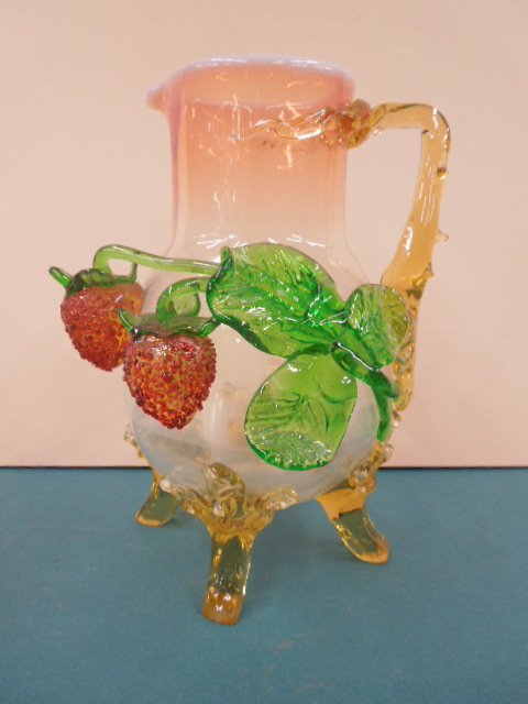 Stevens & Williams (attributed) Glass Pitcher: Stevens & Williams (attributed) glass pitcher, with amber applied handle, feet & green & ruby glass strawberry appliqueé, 19th C. CONDITION: Minor chips on feet; crack in body under one strawberry.