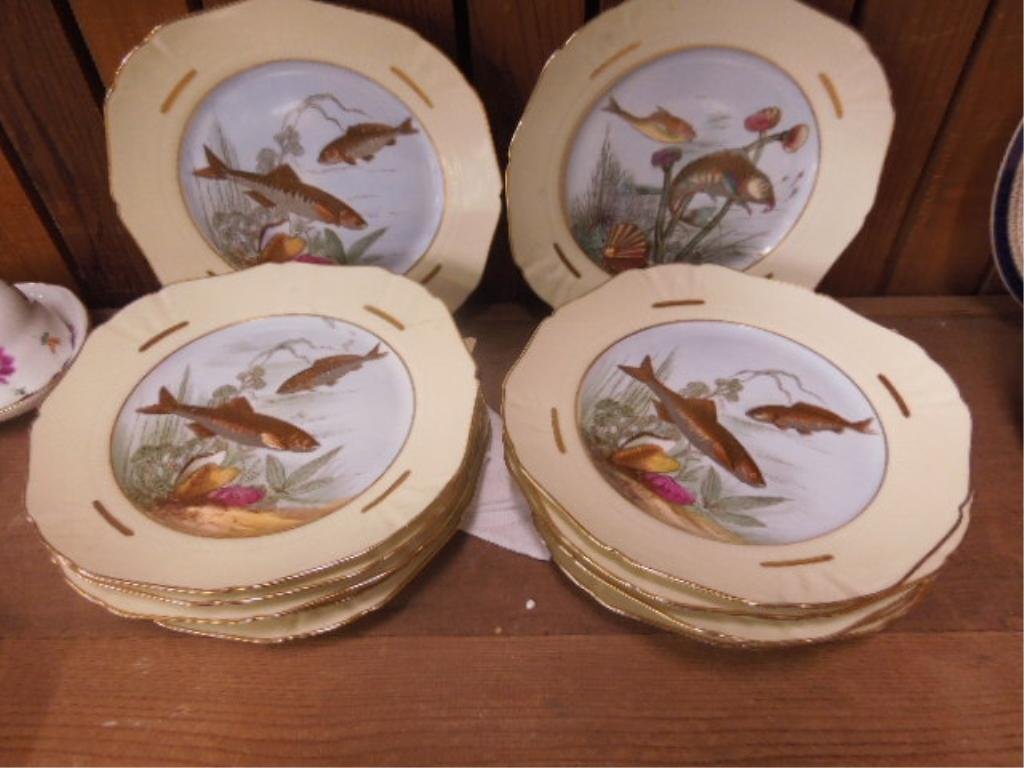 Set of 12 M. Redon Limoges Plates: Set of 12 M. Redon Limoges porcelain fish plates, stenciled & hand painted swimming fish, yellow borders with gold highlights, early 20th c. 9 1/4"d. CONDITION: One plate with old rivet repairs, minor
