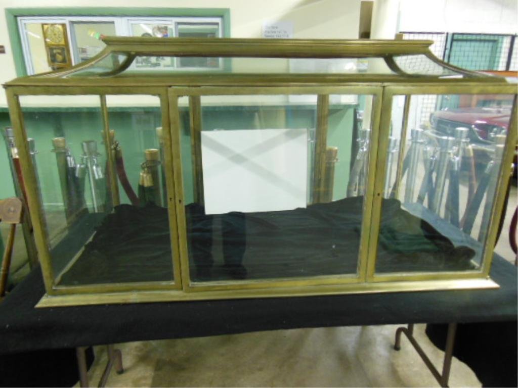 Casket-form store display cabinet: Brass frame and glass casket-form store display cabinet. American, early 20th C. [Provenance: by tradition in the consignor's family, this case was originally installed at Tiffany's, New York.] 28 1/2