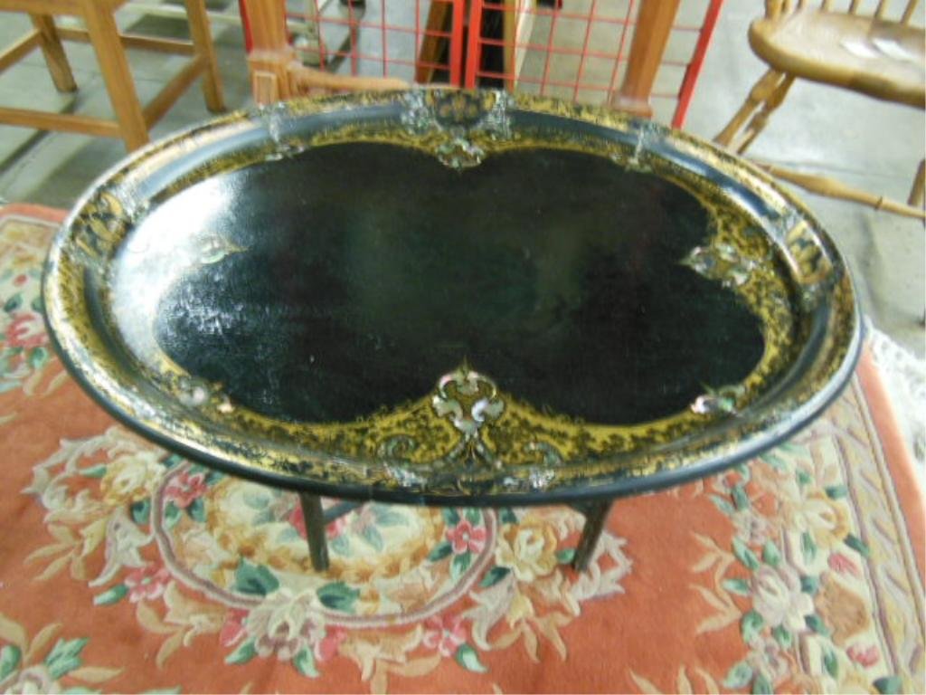 Victorian Papier Mache Tray Table: Victorian papier mache tray table, black with gold stencil scrolled borders with mother of pearl inlay, contemporary folding wood base, 19th C., tray 31" x 24 3/4". CONDITION: Crazing to finish.
