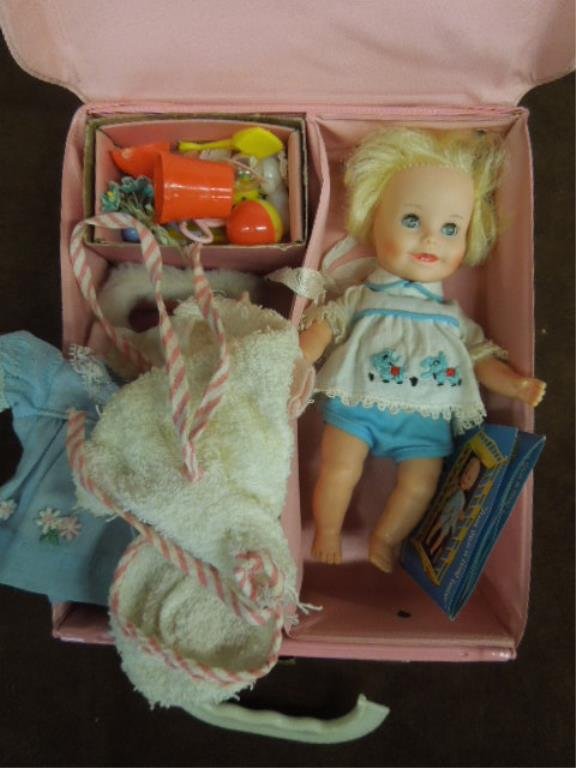 Suzy Cute Doll, Clothes & Accessories: Suzy Cute doll, clothes & accessories, in pink plastic doll case, 7 1/4" h, with red snow wear, 5 outfits & terry robe, plus rattles, bottles, beach & tub items. CONDITION: Minor wear on doll, case ha