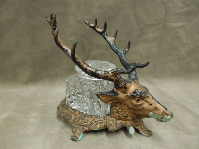 Stag Head Form Glass Inkwell, Cast Iron Base: Stag head form, glass inkwell cast iron base, swirl pattern covered inkwell, 5 antler form pen holders, 5 1/2" x 7" x 5 1/2", late 19th C. CONDITION: Chip on underside of lid copper paint loss on base