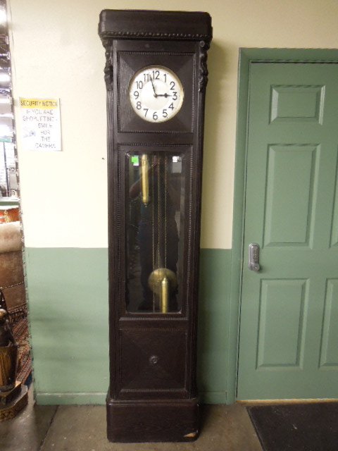 German Tall Case Clock: German tall case clock, dark oak with acanthus, reed, rosette & other carvings, silvered dial, brass double weight chain drive time & strike movement, early 20th C., 86" height. CONDITION: Small venee