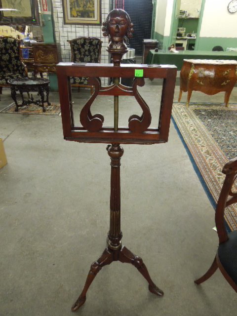 Music Stand: Music stand, mahogany crested by a sculptured bust of a musician over two adjustable sheet music shelves, reeded adjustable height column on three human form legs with shoe feet, late 20th C., 60" hei