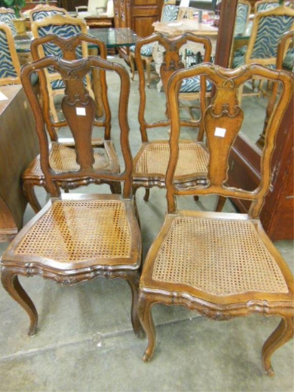 Set of 4 French Provincial Side Chairs: Set of four French Provincial side chairs, fruitwood, serpentine crest over urn splat & caned seats, floral carved serpentine apron & cabriole legs, early to mid 20th C., height 38 1/2". CONDITION: On