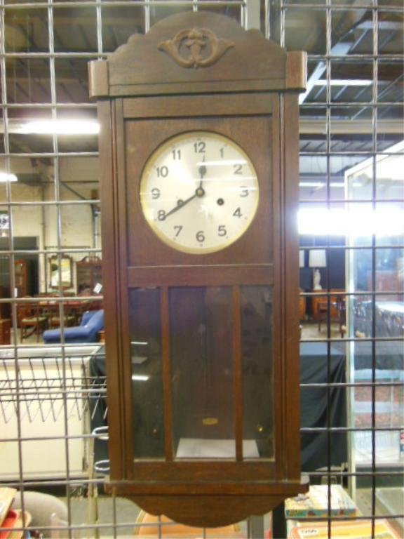 German Wall Clock: German wall clock, oak silvered dial with time & strike movement, early 20th C., 13" x 3 1/4" x 6". [8] CONDITION: Currently not running, normal wear.