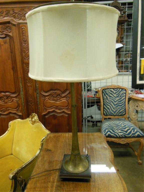 19th C. Brass Horn Lamp: 19th C. brass horn, with mouthpiece, converted to a lamp, rests upon a footed ebonized brass base, horn height 19". CONDITION: Tarnished.