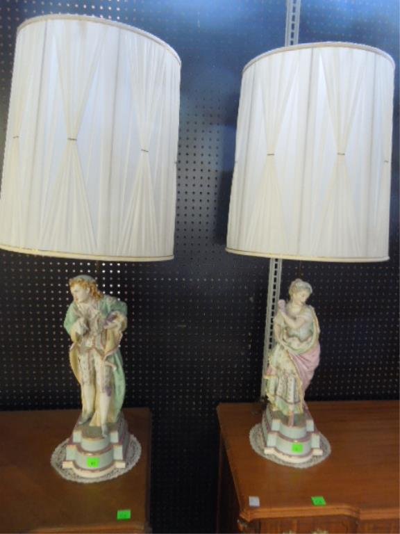 Pr Bisque Figural Lamps: Pair of bisque figural lamps, elaborate hand painted male & female figures on bisque bases, early 20th C., figure height 21 1/2". CONDITION: Baby finger missing from man.