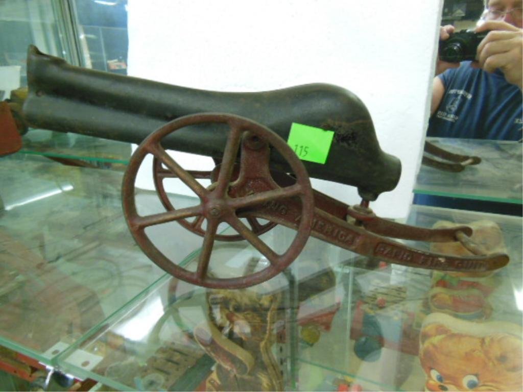 Rapid Fire Cast Iron Gun / Cannon: Young America rapid fire cast iron gun/cannon, 15" l x 7" x 4" w. CONDITION: Fair, wear & paint loss firing mechanism broken.