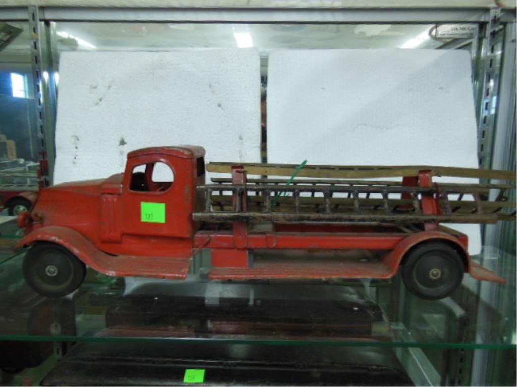 Steel Ladder Truck: Vintage pressed steel ladder truck, 28" long with ladders x 8" tall. CONDITION: Fair, used, some paint loss, ladders have slight bends. Missing headlights.