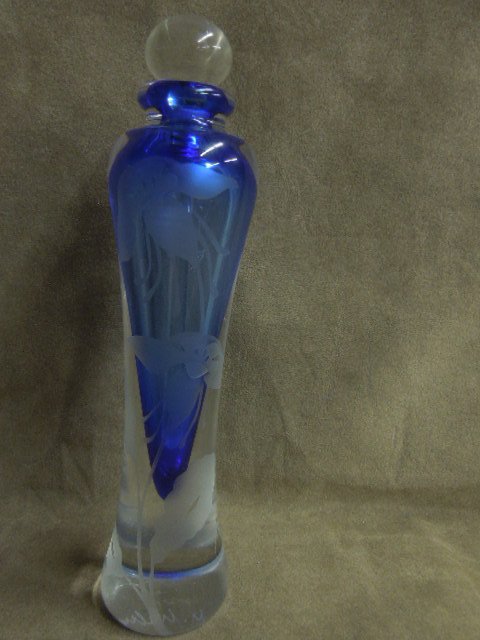 Floral etched perfume bottle: Clear crystal, floral etched perfume bottle, blue inside well, with ground end clear crystal stopper marked J. NA, 2001, M Malu on bottom, 1 7/8" diameter x 7 3/8"h (including stopper). CONDITION: No