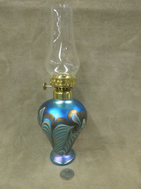 Vandermark Art Glass Fluid Lamp: Vandermark art glass fluid lamp, #58, blue iridescent, white flowers with grey vines, 3 3/4" diam. x 7"H (to brass rim), marked on bottom, late 20th c. CONDITION: Very minor wear, no wick.