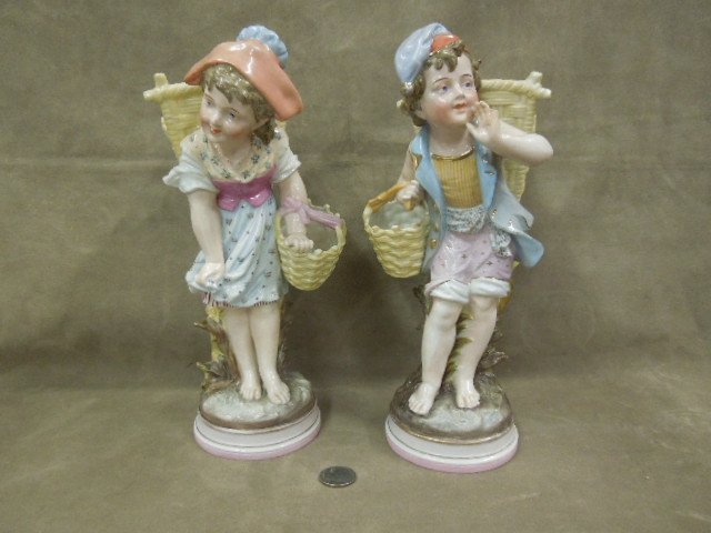 Pr KPM Porcelain Figures 1513 / 23: Pair of KPM porcelian figures, #1512 / 23, girl & boy with baskets, 11 1/4" h each, KPM & incised # at bottom. CONDITION: Boy's pinky finger off, otherwise - no chips, cracks or crazing.