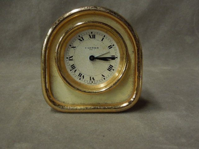 Cartier Travel Clock: Cartier (Paris) travel clock, with "C: form footed hinged clock rest, missing crystal, Swiss made, 750407695 no set time key, 3 1/8"h. CONDITION: Pitting on brass, no crystal, no set time key.