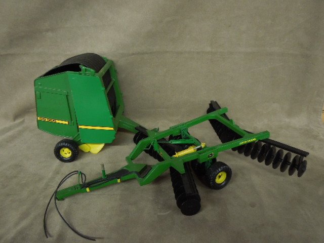 2 John Deere Farming Trailers: Two John Deere farming trailers. One plough, one hay roller. CONDITION: Good, used.