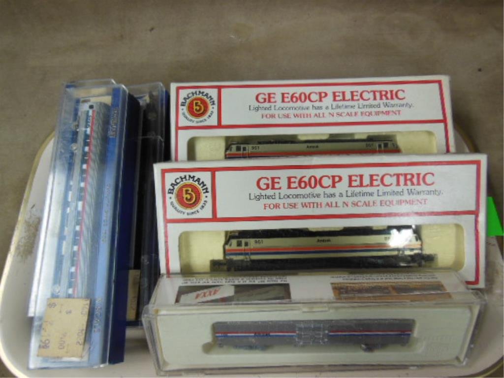 6 "N" Gauge Amtrak Trains: Six "N" gauge Amtrak trains, old store stock featuring two Amtrak GE E60CP locomotives, one boxcar & three passenger cars in original boxes. CONDITION: Good OSS.