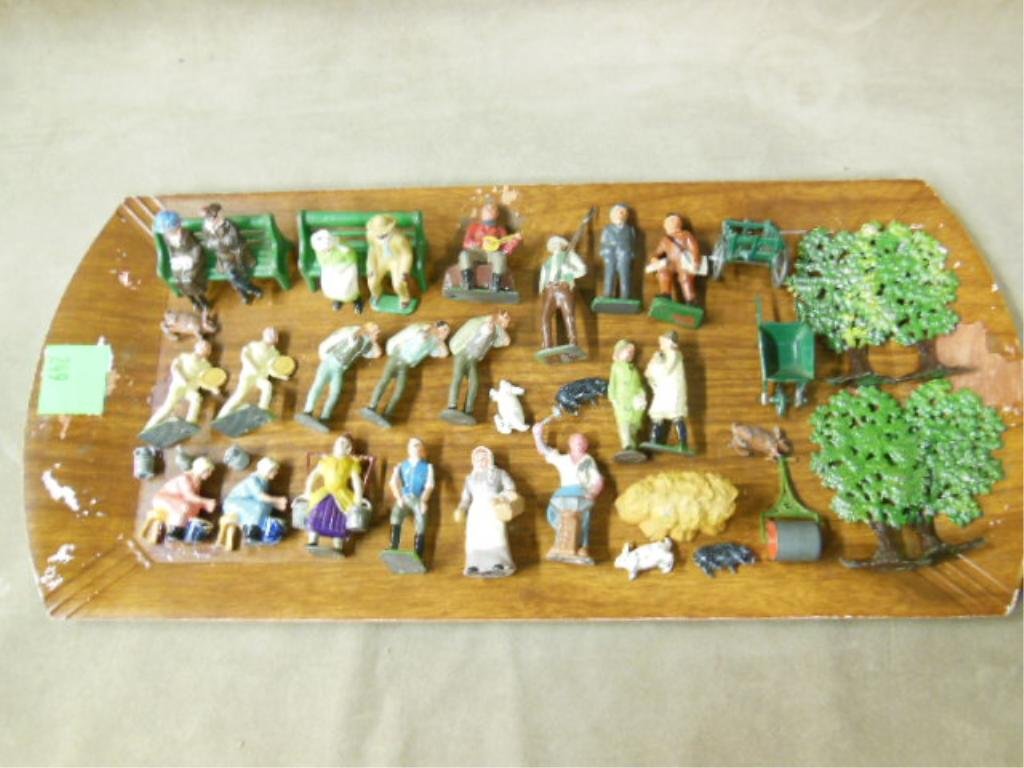 21 Lead Figures & Accessories: Twenty-one lead figures & accessories, including men & women (African American man, one with movable arms) laborers, tennis & banjo players, rabbits, pigs, wheel barrows, roller, hay stack, 4 trees (o