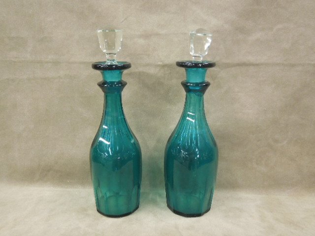 Pair 19th c Teal Glass Decanters: Pair 19th c. teal glass decanters with ribbed panels and clear glass stoppers, hgt 13 1/8". CONDITION: Stoppers are probable replacements; minor base rim nicks, one bottle has a crack at the bottom.