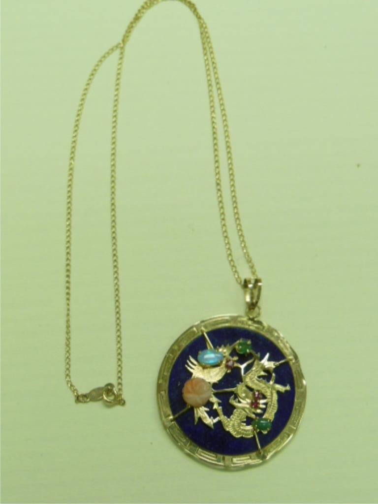 Chinese Gemstone & Gold Pendant: Chinese gemstone & gold pendant, 14k yellow gold 15" thin chain with a 1 1/2" gold framed pendant with Lapis center crested by a gold dragon with oval, emerald, ruby, jade & a rose carved coral, 5 DWT