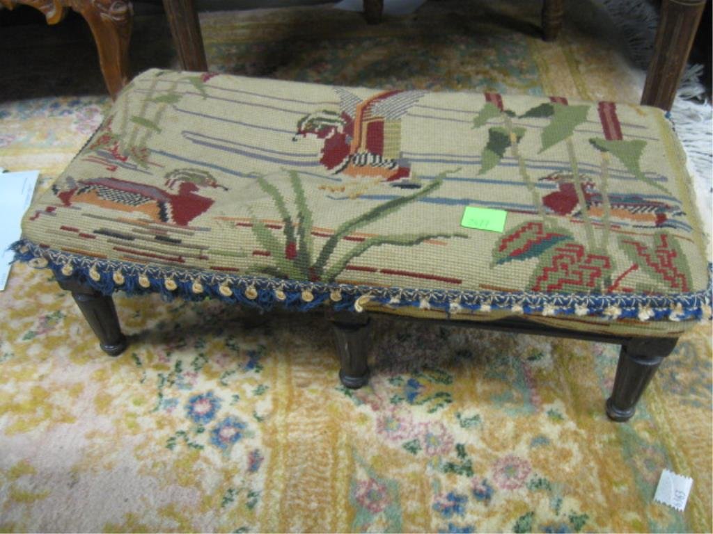 Louis XVI Foot Stool: Louis XVI foot stool, six reeded & turned legs, straw backed needlepoint seat depicting ducks; 19th C. 21" x 11" x 7" CONDITION: Fraying to fringe, seat stuffing loose.