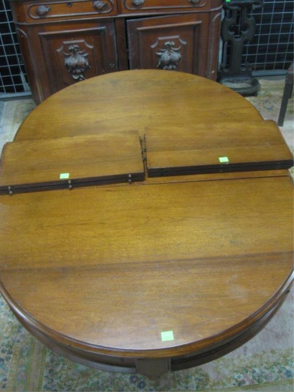 Renaissance Revival Extension Dining Table: Renaissance Revival carved walnut extension dining table with carved bosses & shaped incised panels upon skirt, single pedestal base with corresponding carved motifs; three leaves, American, c. 1870.
