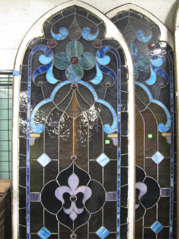 Pr Tall Leaded Glass Window Panels: Pr tall Leaded window Glass Panels, wood framed arched top, fleur de lis, button and clover decoration, 108 1/2" h x 39 1/4" w each CONDITION: 1 panel has 1 pane cracked at top right, frames have wear