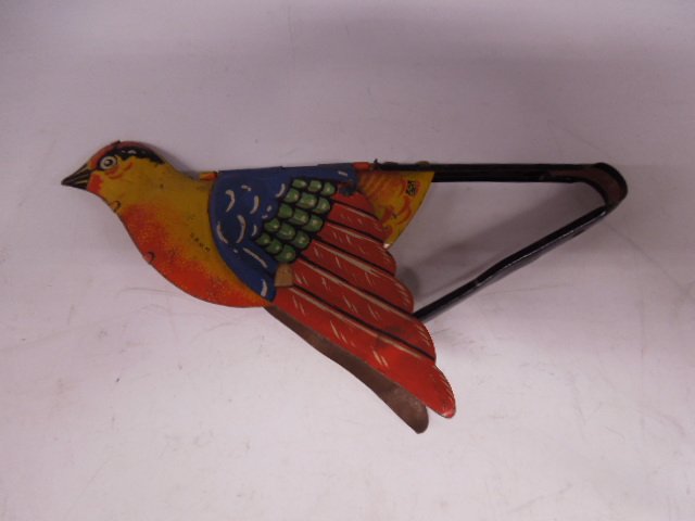German Tin Squeaking Flying Bird: German tin squeaking flying bird, "D.R.G.M." model 153, with paper bellows, 7"l, 3 1/4" h, early 20th C. CONDITION: Wear, working condition.